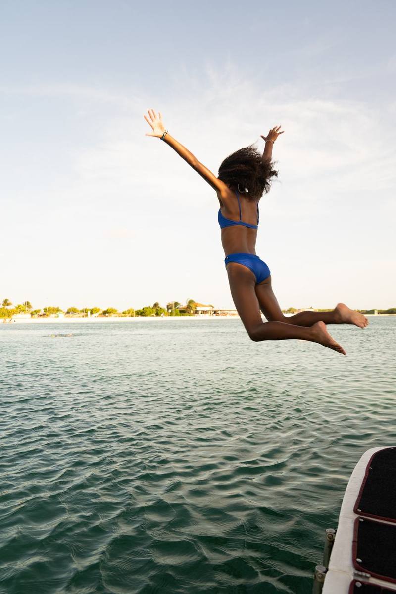 Girl leaping off the boat into the lagoon